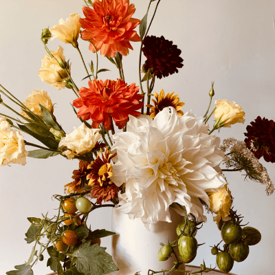 A coloured flower arrangement in a white vase.