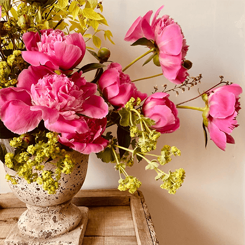 A bouquet of pink flowers in a beige vase